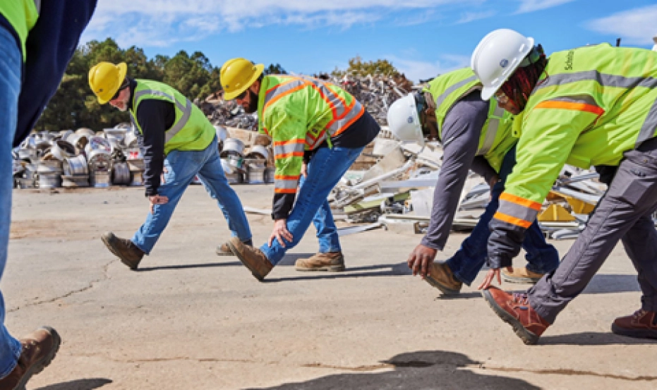 Recycling employees stretching during safety meeting