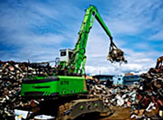 Green material handler lifting scrap metal