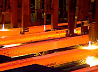 Steel beams being processed in rolling mill