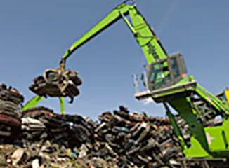 Material handler sorting large scrap metal pile