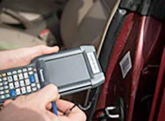 Technician scanning vehicle barcode for recycling intake