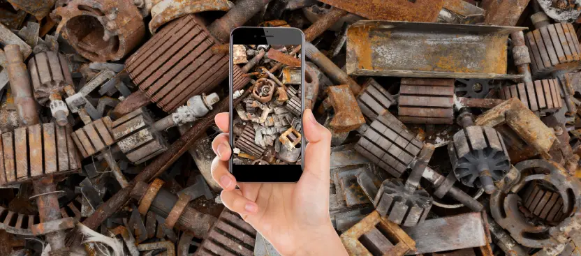 Person holding phone with scrap metal photo