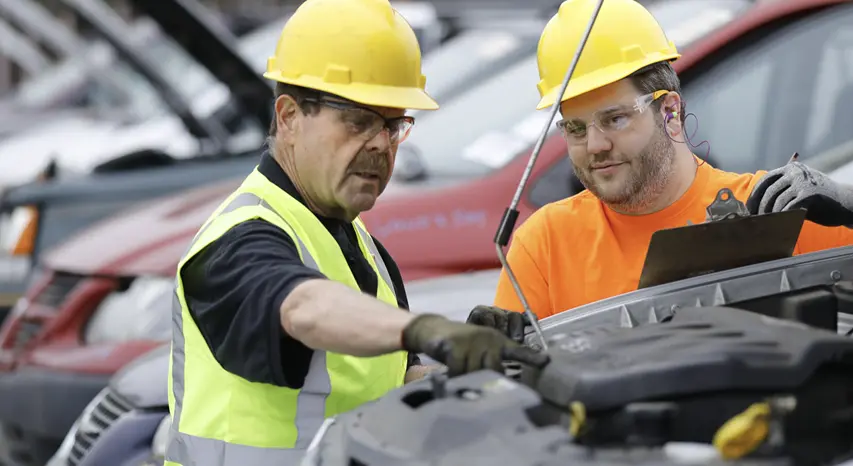 Radius Recycling team inspecting a vehicle to sell a car for parts and recycling