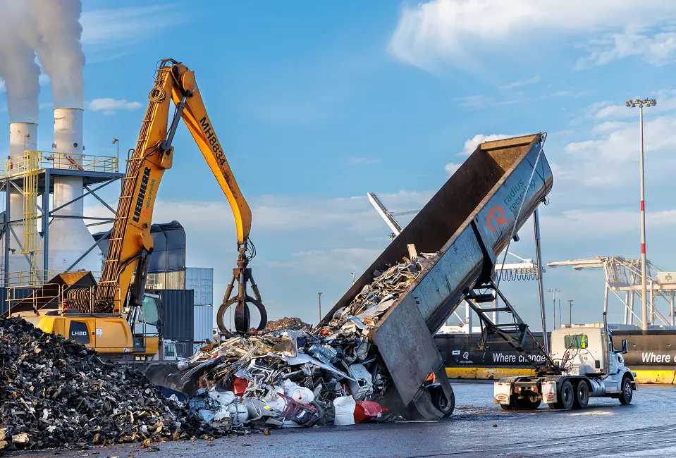 Scrap metal being unloaded at industrial recycling site